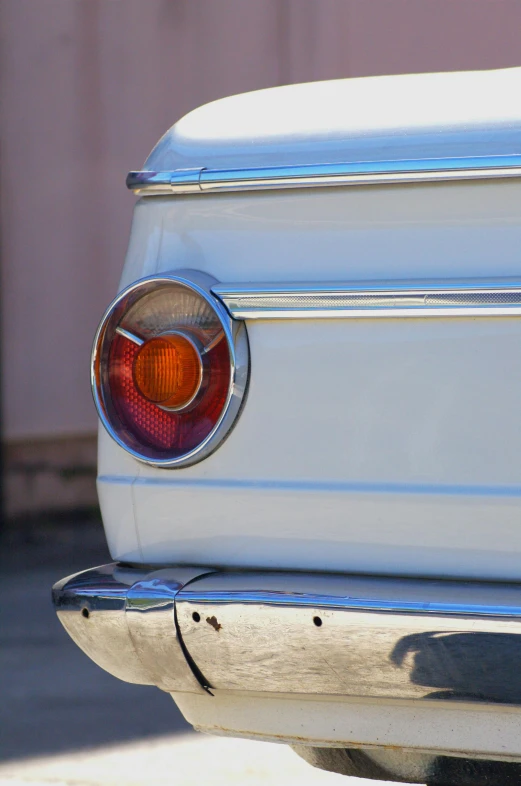 an old, white, vintage mustang sitting on top of a sidewalk