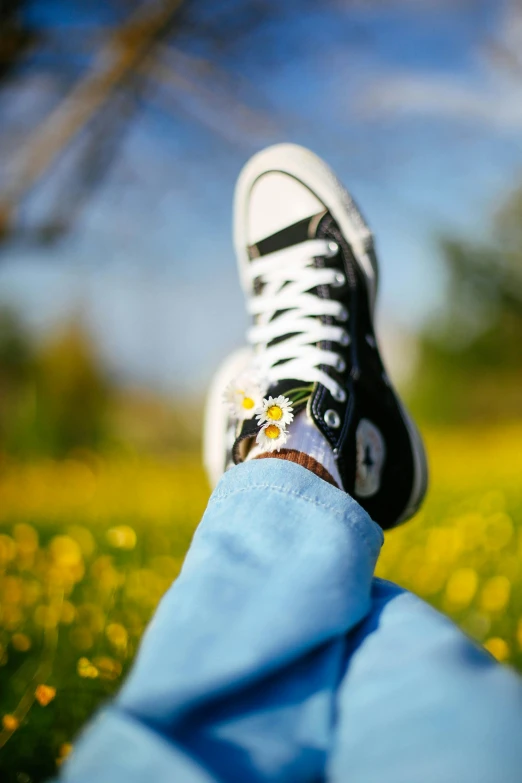 the view of someone's feet wearing sneakers in the grass