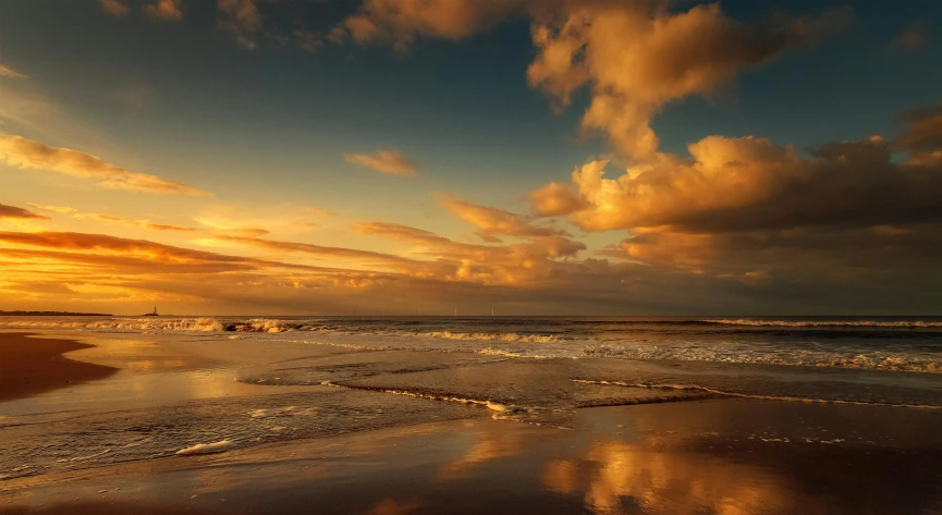 clouds hang low as the sun sets at the beach