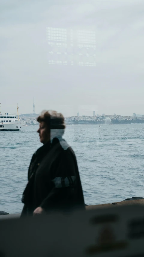 a man in black jacket looking out over ocean