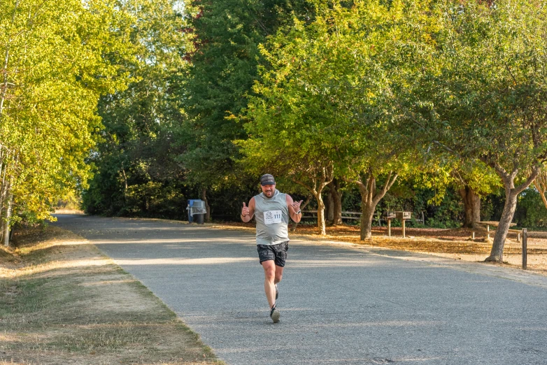 a man running down a road near trees