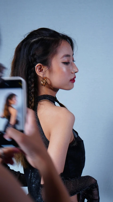 an asian woman wearing an embellished black dress