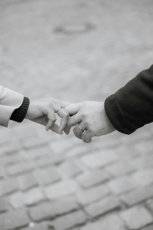 two people are holding hands with each other