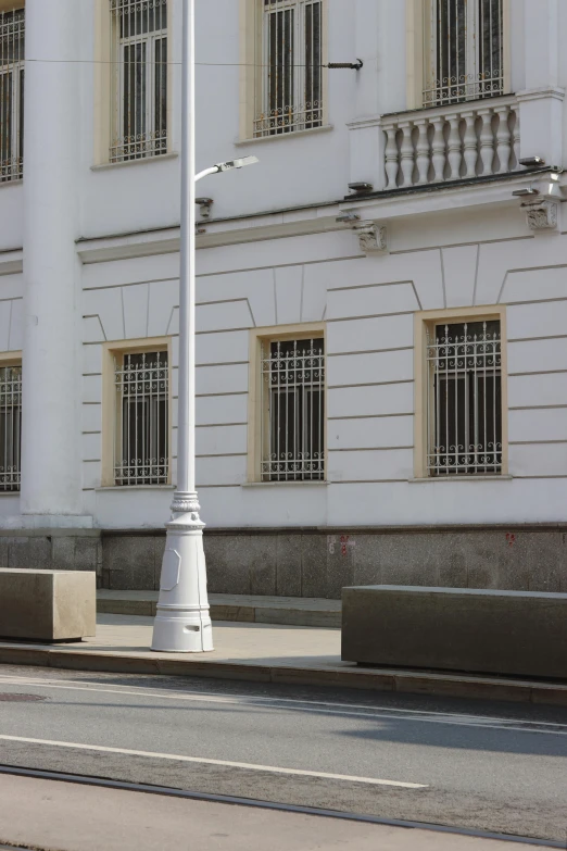 a white lamp post next to a tall white building