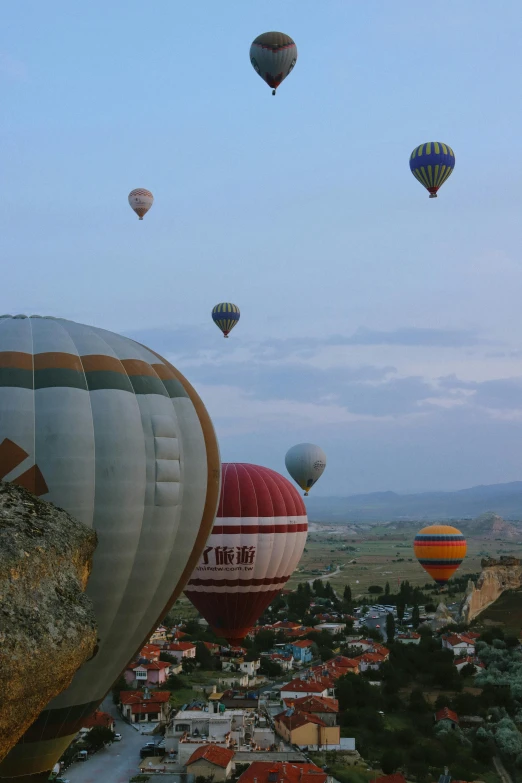 many balloons flying in the sky with a city below