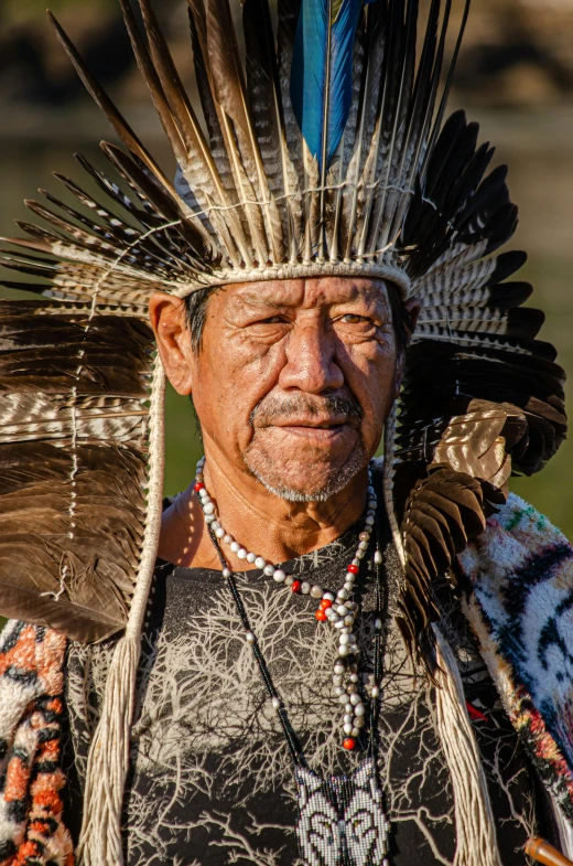 an indian man in head dress stands