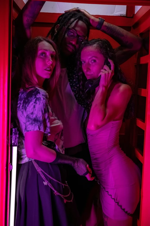 three women standing in the doorway of a small red booth