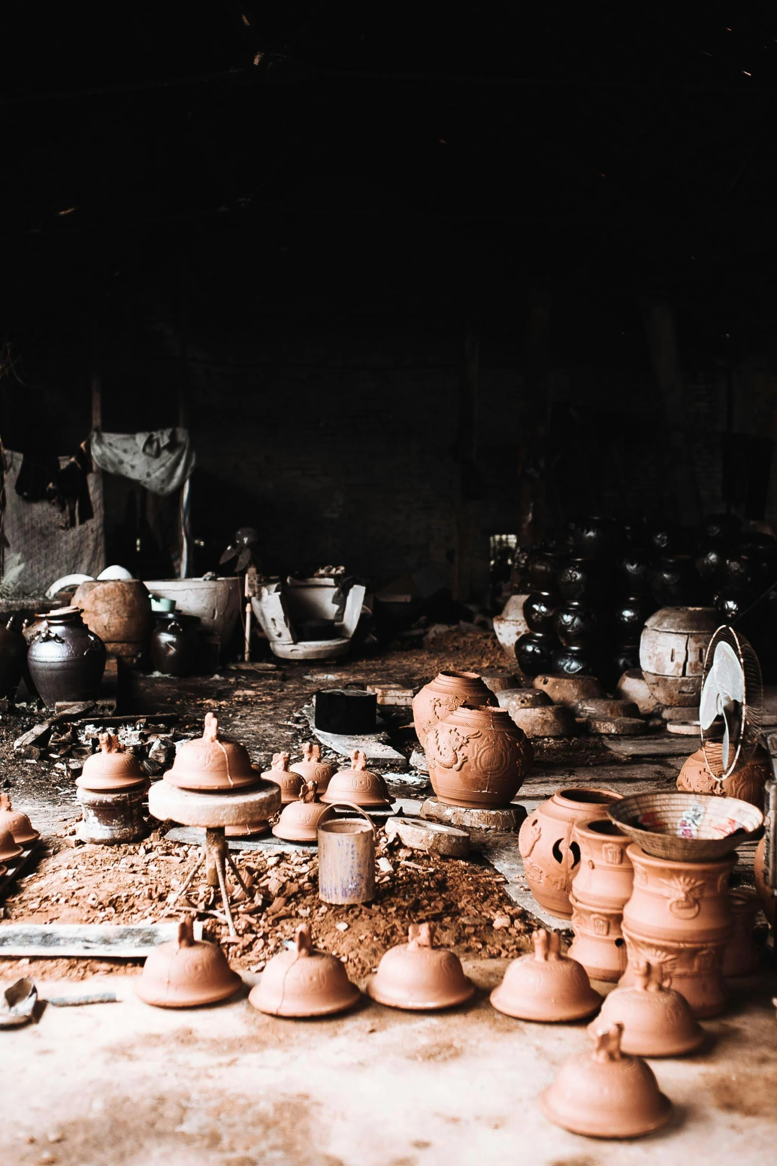an arrangement of pottery is on the floor in front of several pots