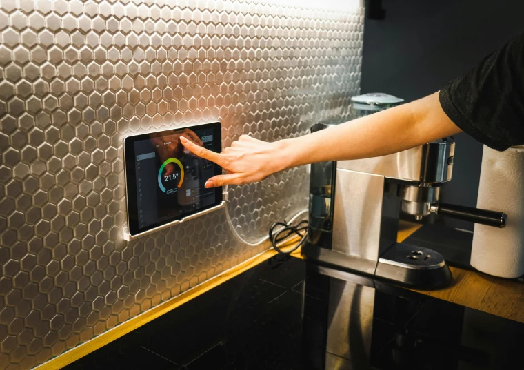 a person pressing the screen of their kitchen appliance