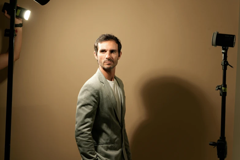 the man is posing in his studio with a light and camera