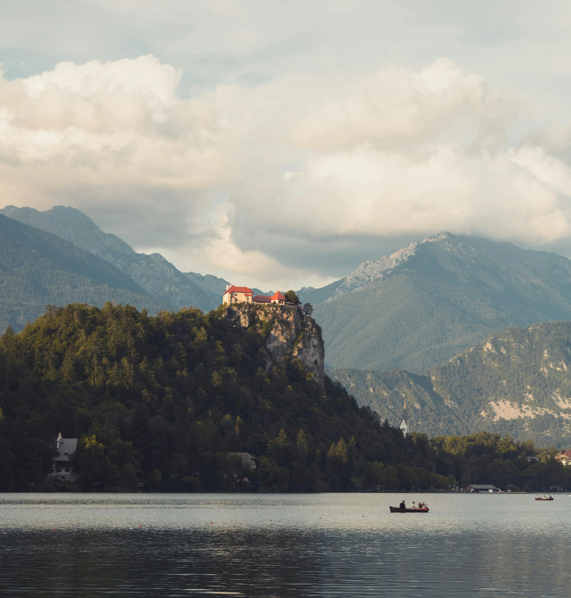 there is a boat in the water and a castle on the mountain side