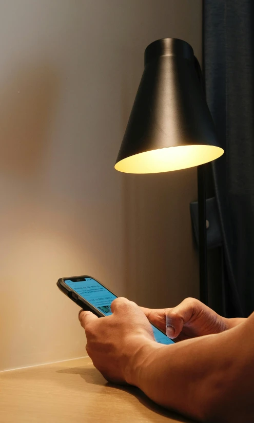 a person is using their cell phone at a table