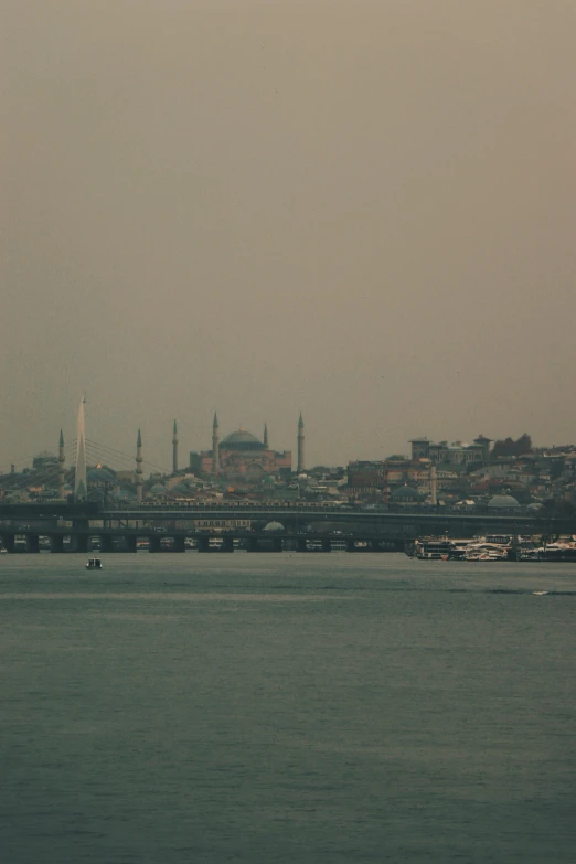 a large bridge over water with a town in the background