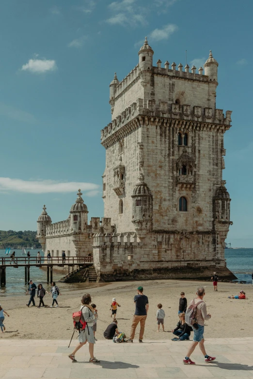 a large tower with many windows sitting on the side of a sandy beach