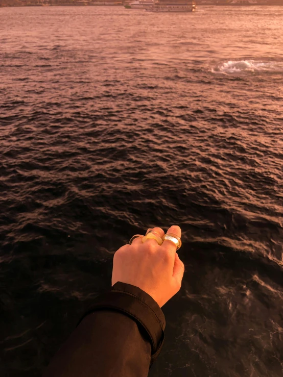 a person on a boat watching the ocean with the sun setting