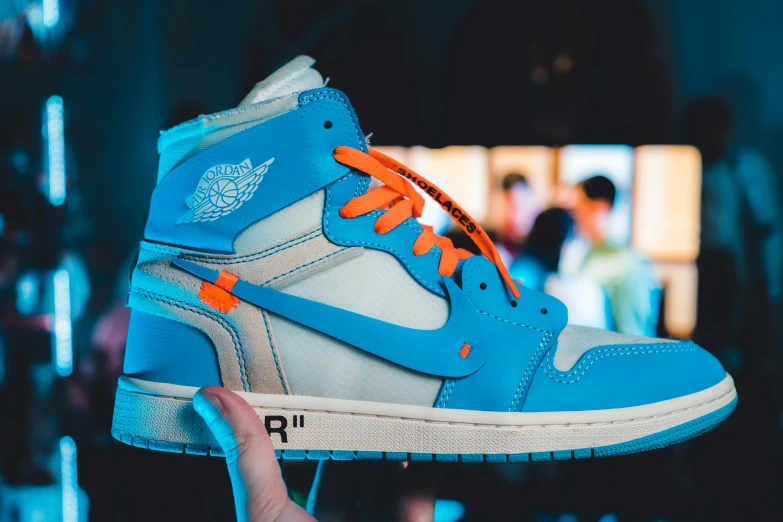 a person is holding up their nike air jordan 1 high