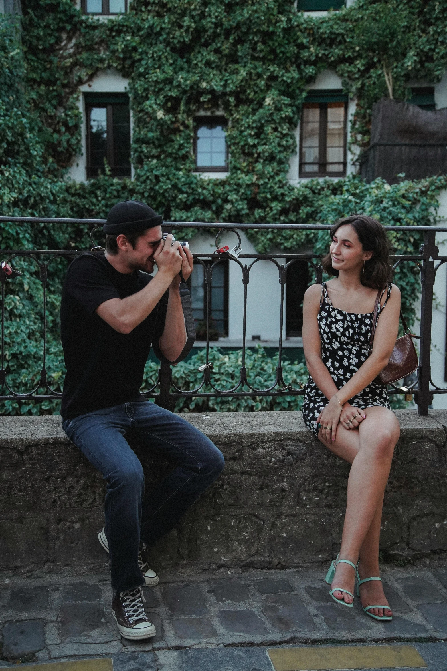 man taking pictures of girl on the sidewalk