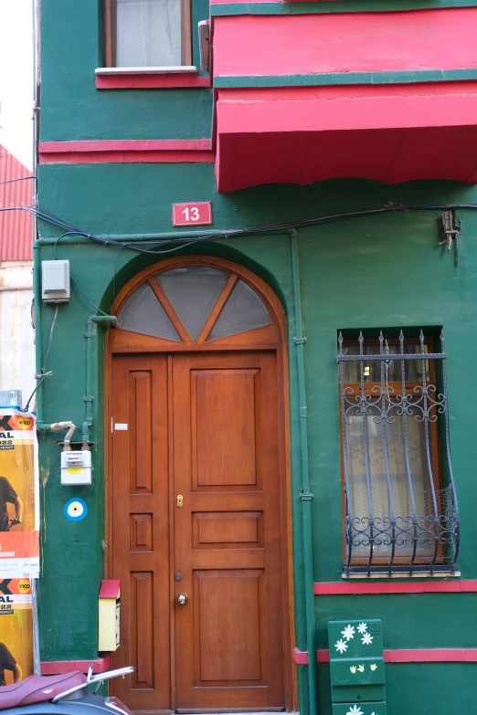 a brown door is in front of a green building