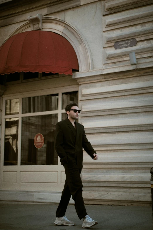 a man in black shirt walking down the street