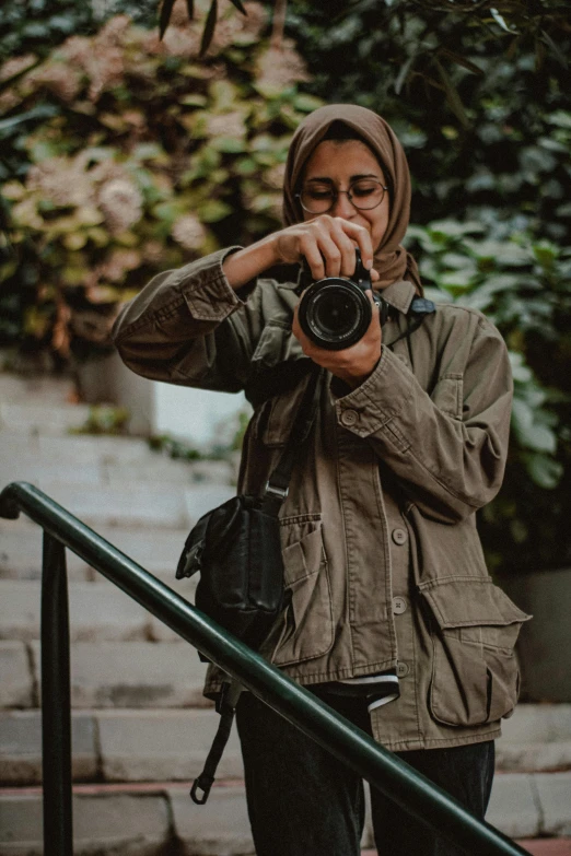 a person wearing a jacket and holding a camera