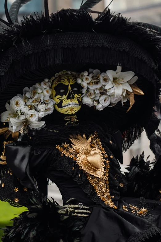 the black and gold mask is next to some flowers