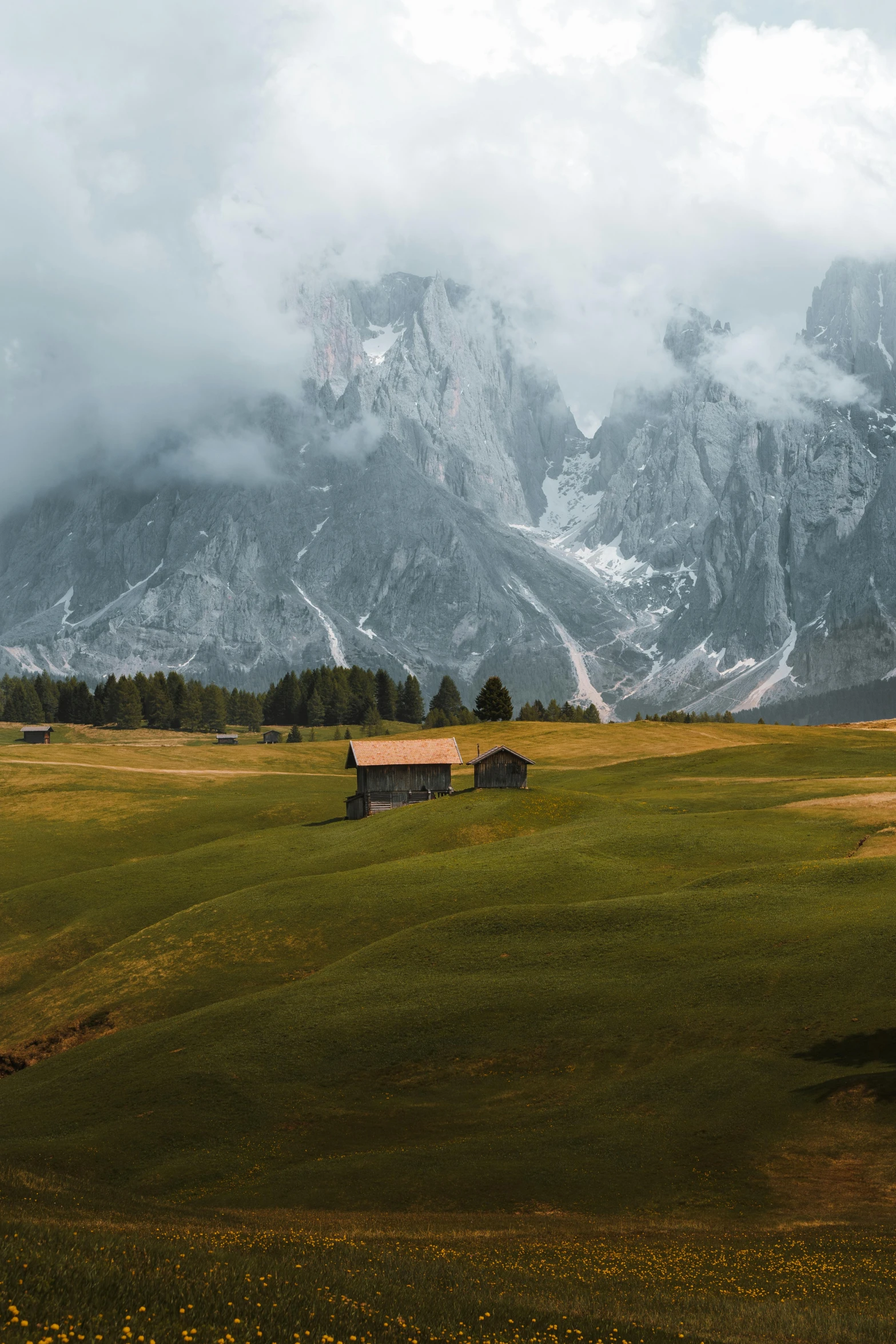 a lone wooden barn in a green field