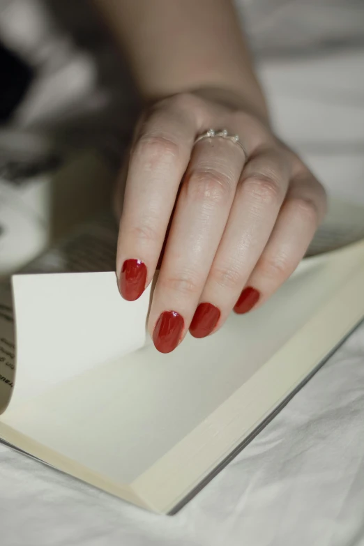 a woman's hand reaching down on an open book