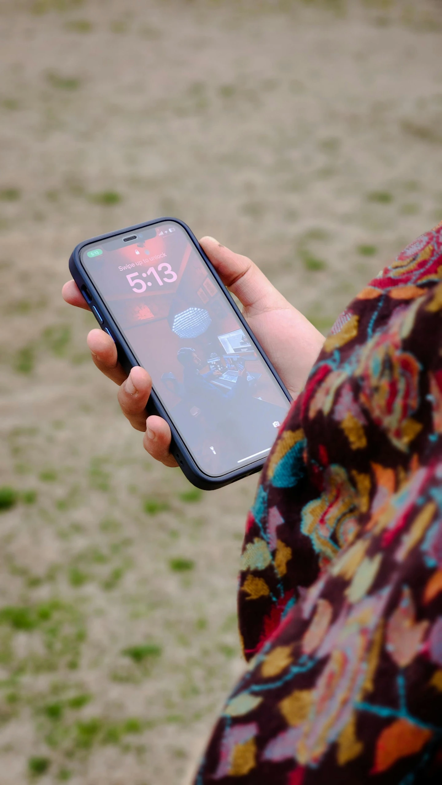 a person's hand holding a cell phone displaying the time