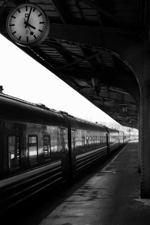 a passenger train parked in a train station next to a clock