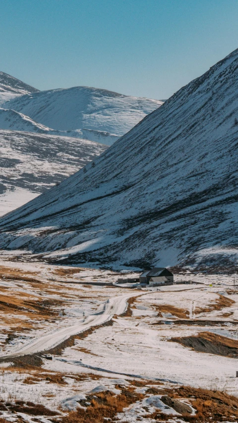 snowy hills covered in snow with a mountain in the distance