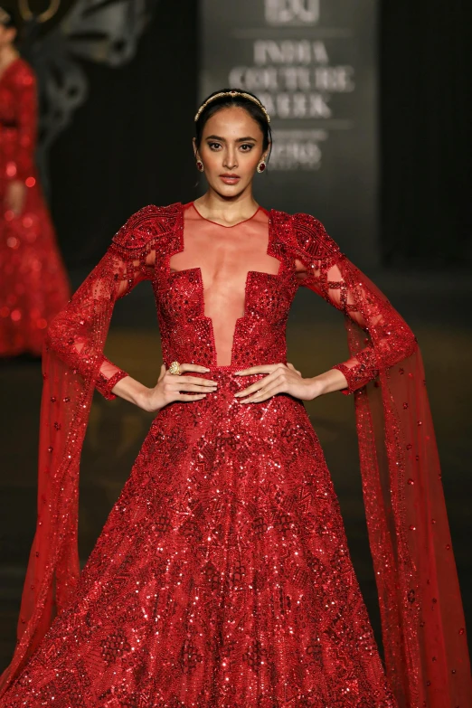 a woman on the runway in a red gown