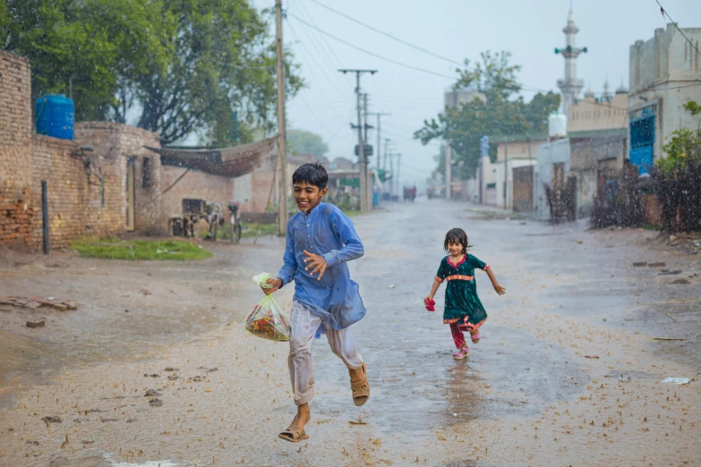 two small children in the middle of an asphalt road