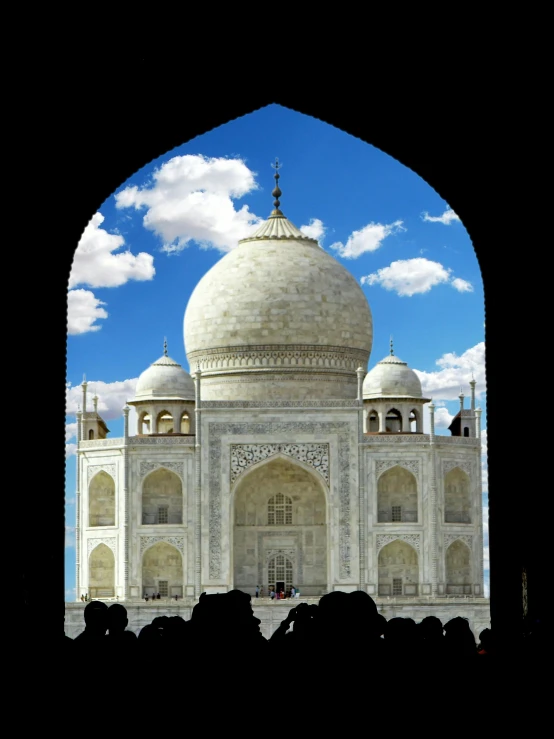 some people in front of an archway and some clouds