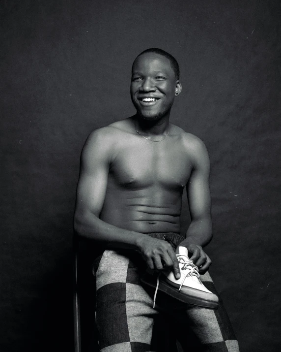 an african man sitting with his sneakers on