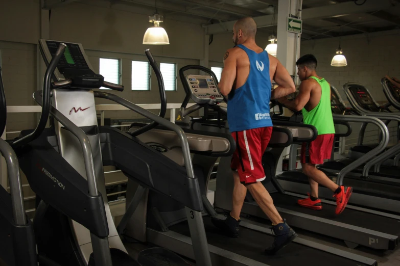 a man running on a treadmill as another watches