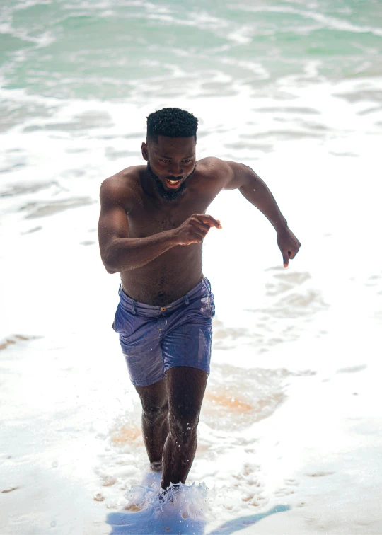 a man running through the water at the beach