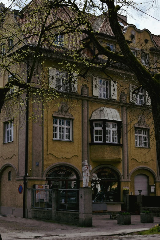 the front of an old, brown building with trees in front of it