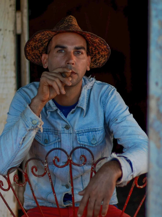 a man in a straw hat smoking a cigarette