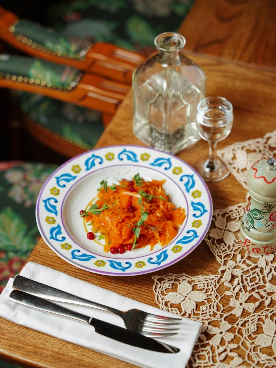 plate of food with spoon and fork near glass and bottle