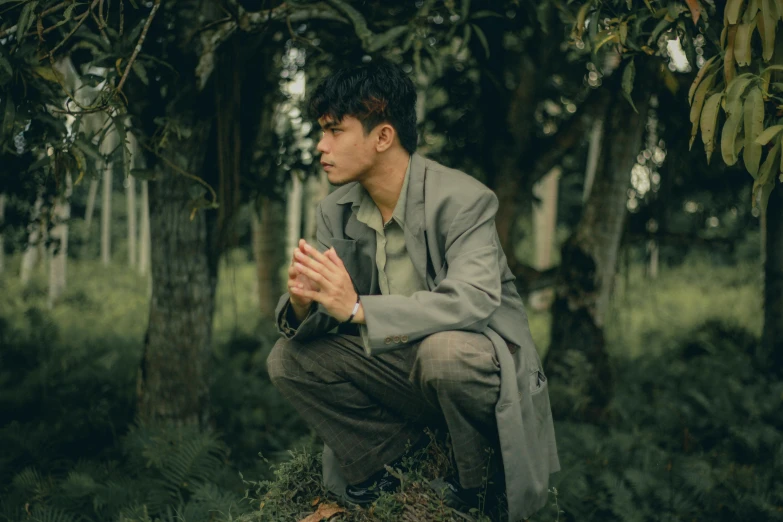 a man kneeling down in the woods praying