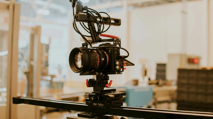 a camera attached to a tripod next to a large glass window