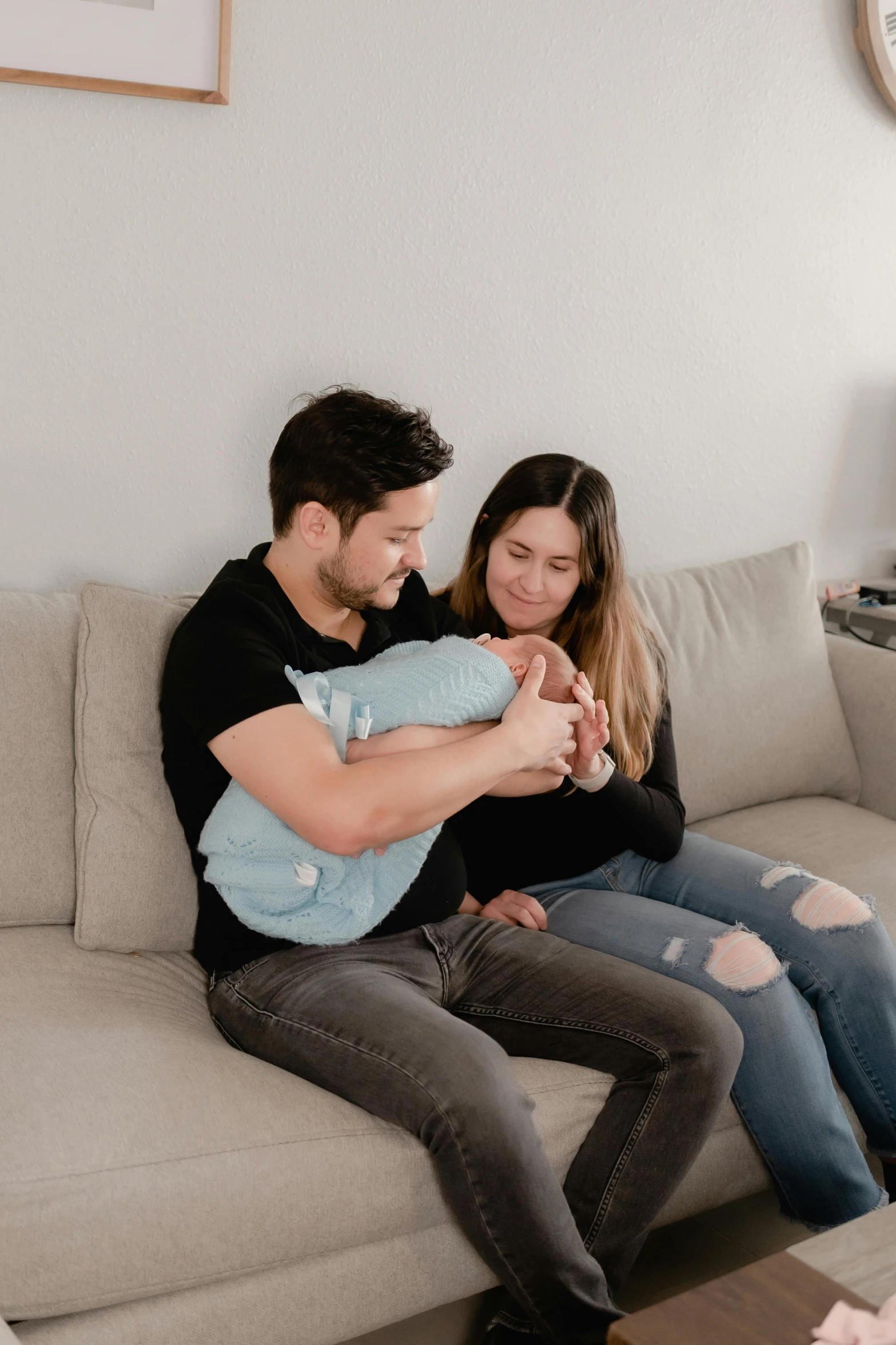 a man holding a girl while sitting on top of a couch