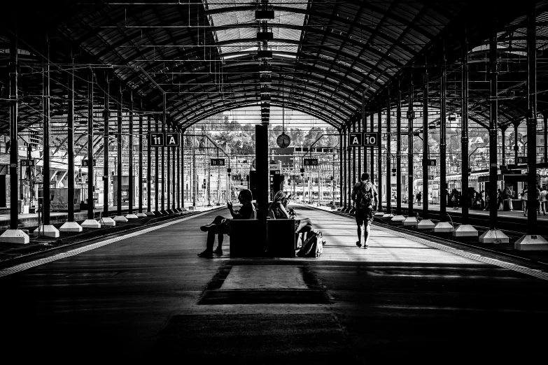 people waiting at a train station next to each other