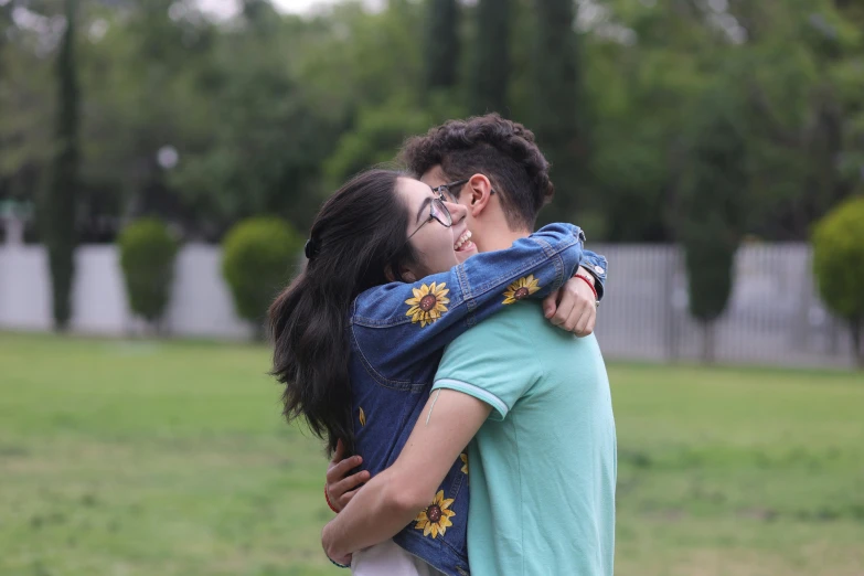 the young man is holding the girl while they hug