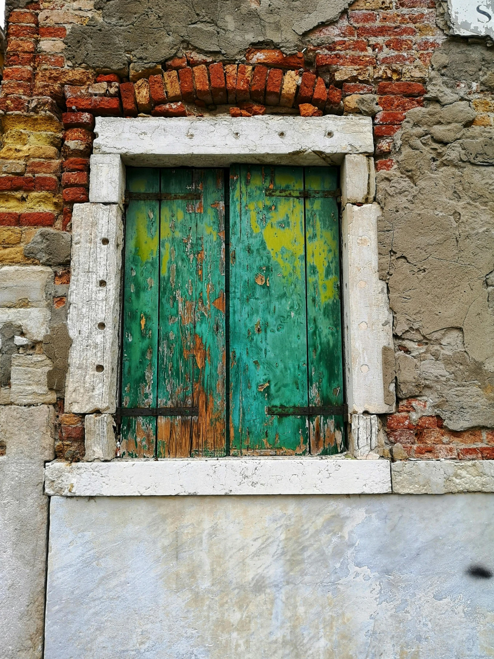 a green door sits in a red brick building