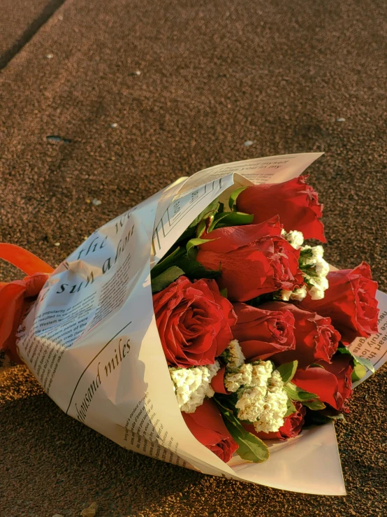 a bouquet of red roses laying on the ground