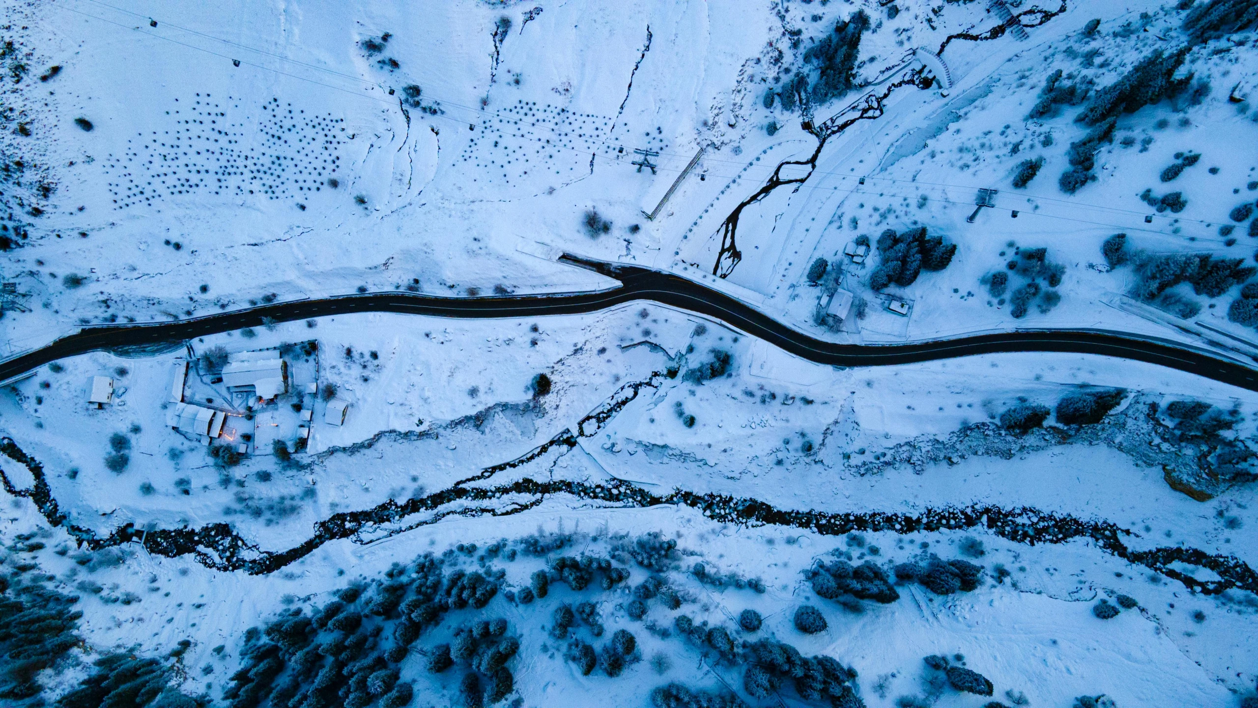 an aerial po of the road going around a snowy mountain