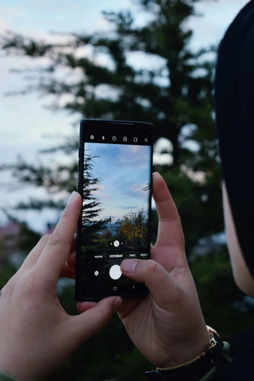 a woman holds up an open phone with a po on it