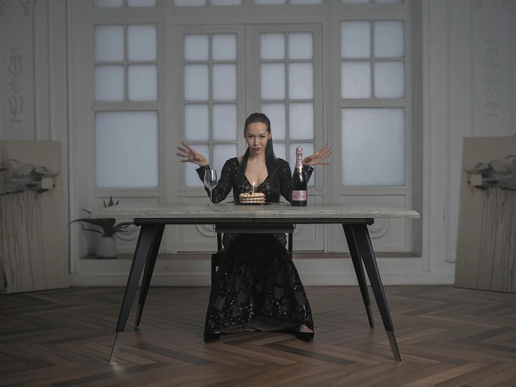 a girl sitting at a table with two wine bottles