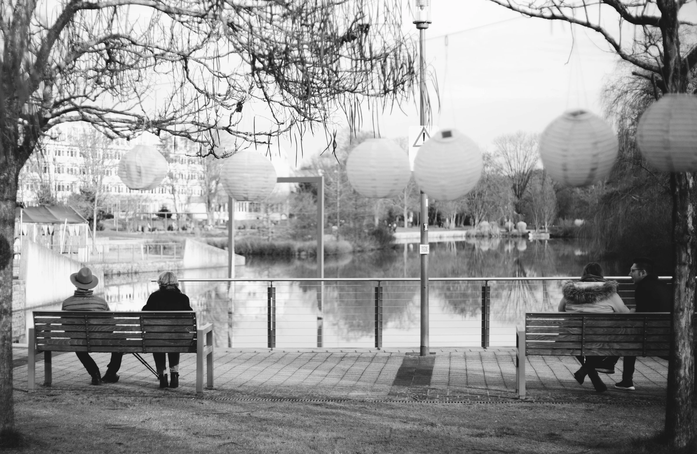 two people are sitting on a bench in the park